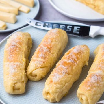 Soft bread rolls filled with cheese topped with sugar and butter